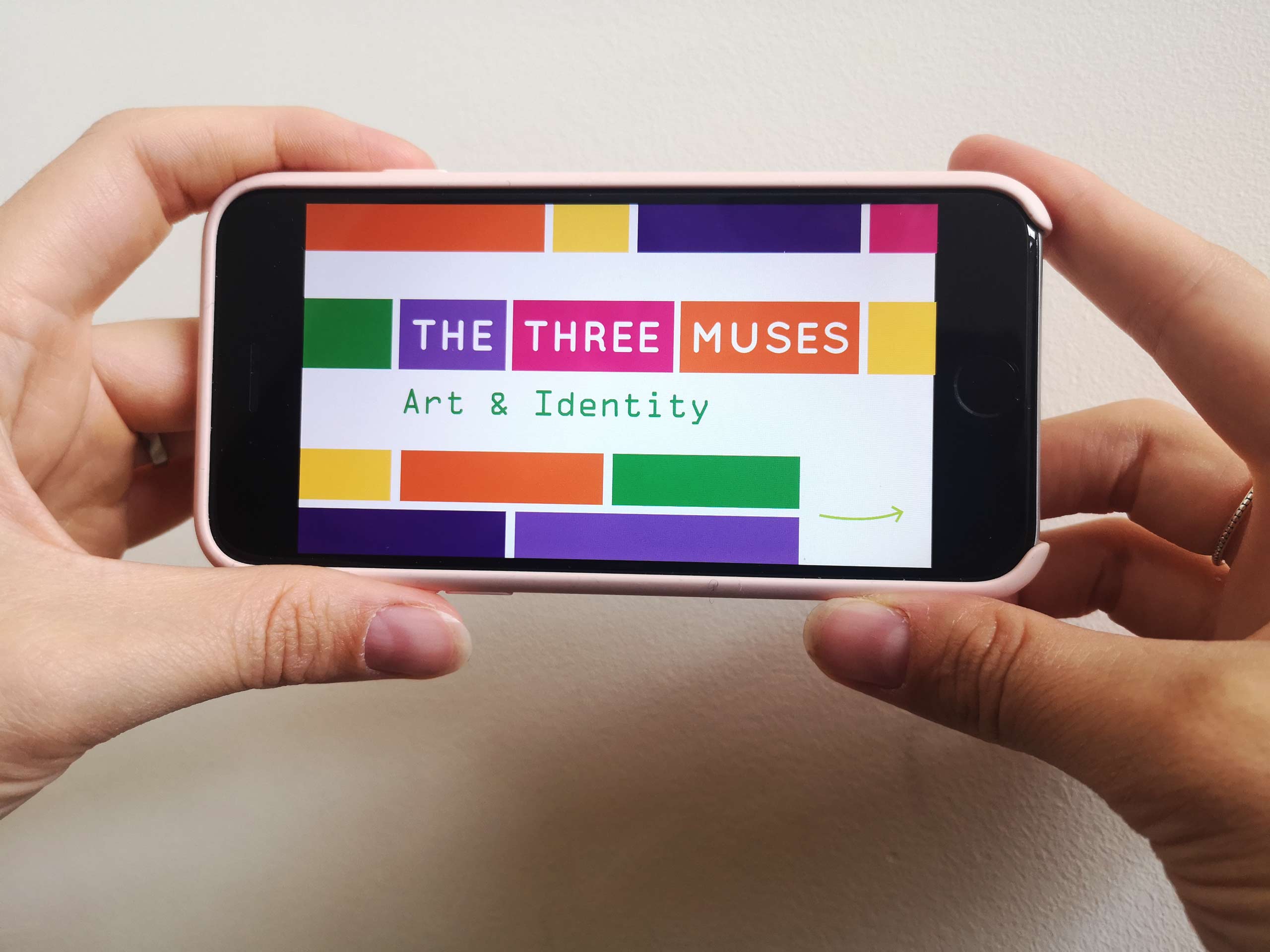 Hands holding a phone in landscape playing The Three Muses